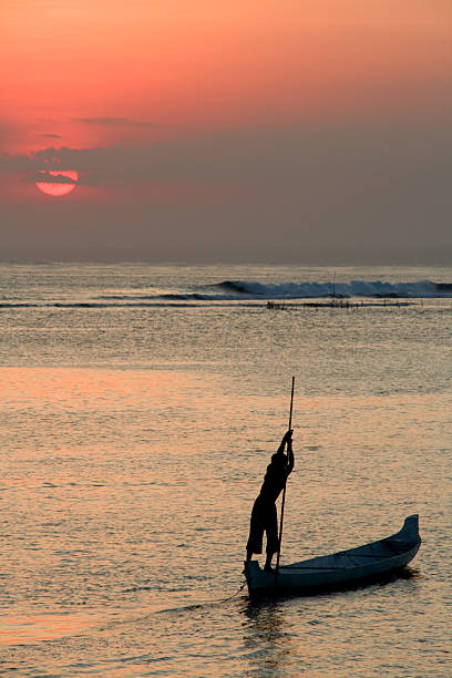 boatman on sun set stock photo