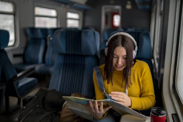istock Young woman in train is reading a map 1470434196