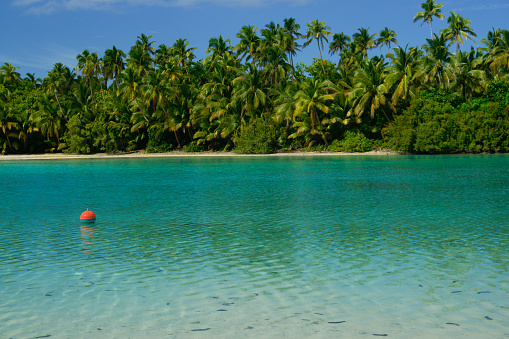 Orange buoy floating in idyllic tropical lagoon in Cook Islands.