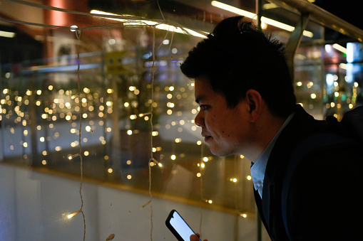 The man holds his phone and looks at the speckled light carefully