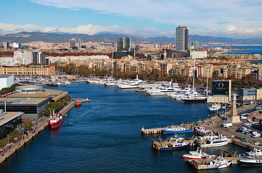 Barcelona, Spain-January 02,2016:Picturesque aerial landscape view of Port Vell with moored yachts and ships in Barcelona. Downtown of Barcelona in the background. Travel and tourism concept.