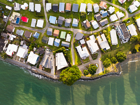 Top looking down at suburban houses next to Waiwera Beach,  North Auckland, New Zealand.