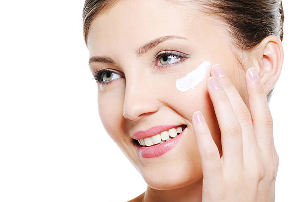 istock Female applying cosmetic cream on face 147043667