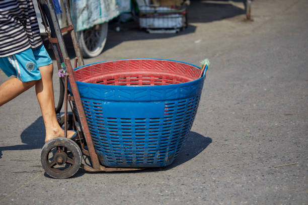 A boy push the large plastic buckets on the cart