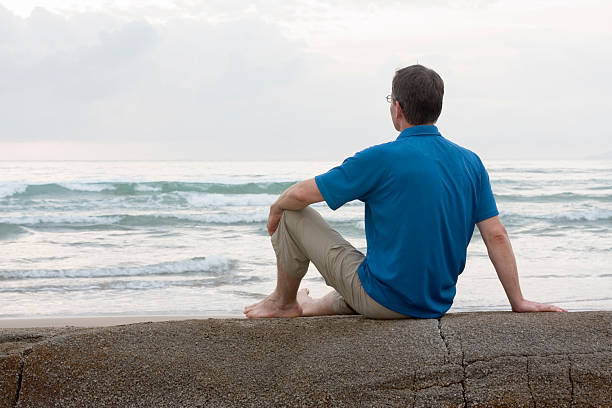 istock Man sitting on a rock at the sea 147043956