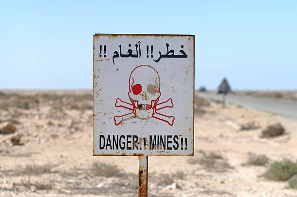 Danger minefield sign Danger minefield sign in the western Sahara near the Mauritanian border. guerrilla warfare photos stock pictures, royalty-free photos & images