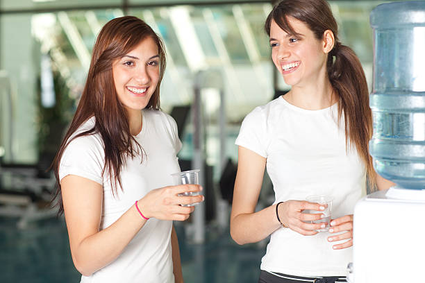 Young women in the gym drinking water stock photo