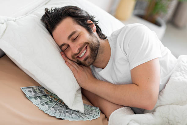 istock Man sleeping with lots of currency notes 1470440653