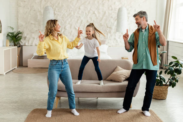 istock Happy Parents And Daughter Having Fun Singing Dancing At Home 1470440816