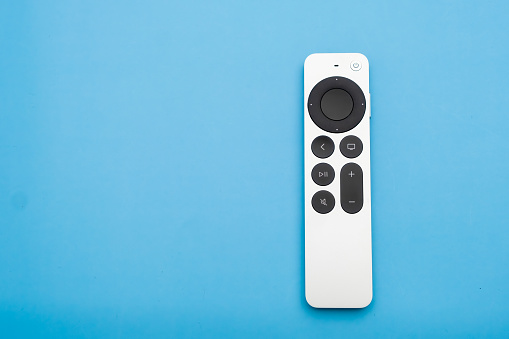 Siri Apple Tv 4k Remote controller on the blue background with copy space, February 2023, Prague, Czech Republic