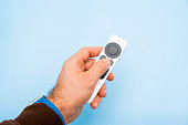 Apple TV 4k Remote controller in mans hand on the blue background