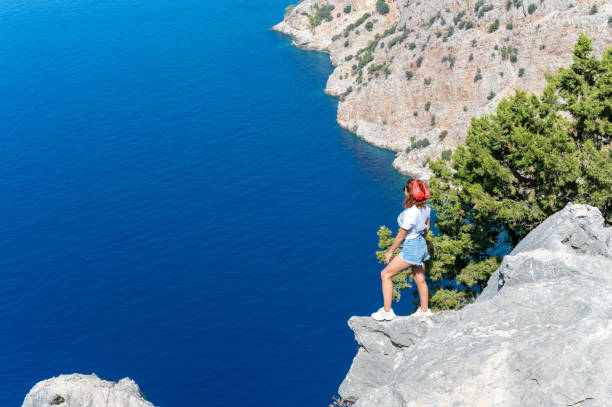 istock Cheerful young woman watching the sea from the cliffs. 1470441937
