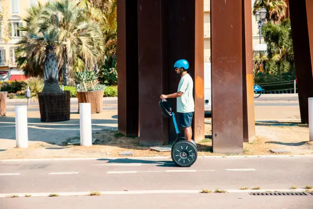 Male tourist travelling by Segway electric vehicle on vacation. Man driving electric scooter on the city street. Copy space