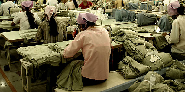 Workers at garment factory in Southeast Asia A garment factory in SE Asia exploitation stock pictures, royalty-free photos & images