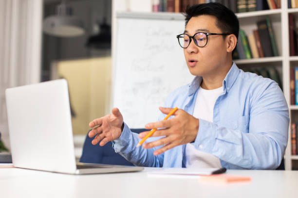 istock Middle Aged Japanese Teacher Making Video Call Teaching Online Indoors 1470444561