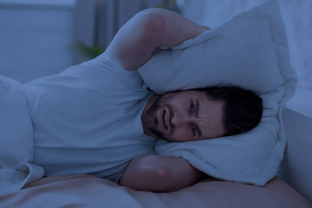 istock Guy in bed covering his head with pillow 1470444701