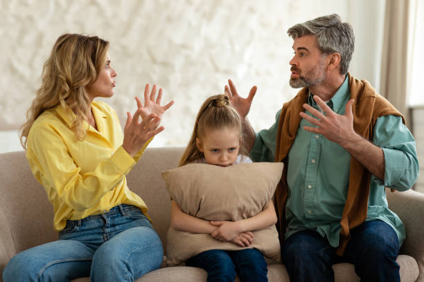 istock Unhappy Daughter Sitting Between Parents While They Having Quarrel Indoors 1470444924