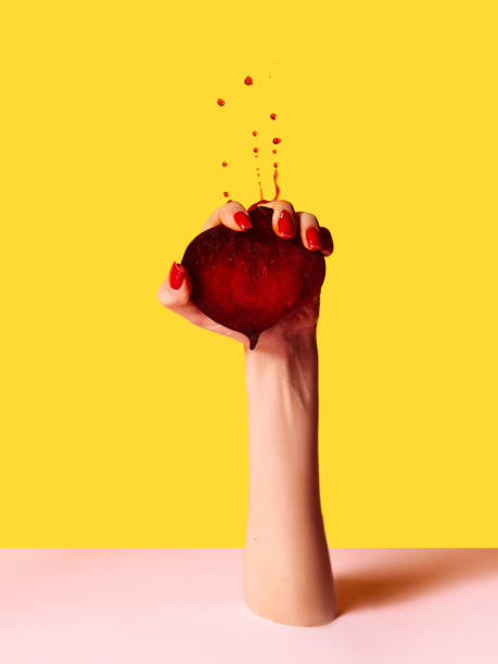 istock Hand squeezes beets with force and drops fly up over pink yellow background. Contemporary artwork. Concept of fashion, creativity, action, surrealism 1470445834