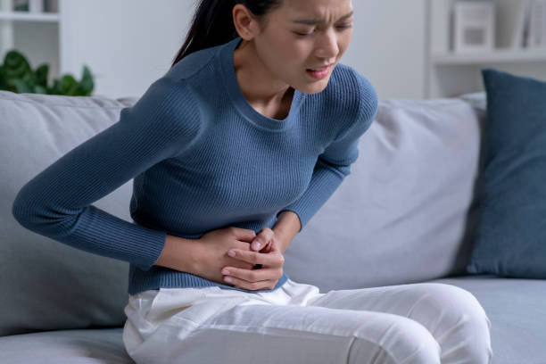 istock Young Asian woman suffering from strong abdominal pain. 1470446884