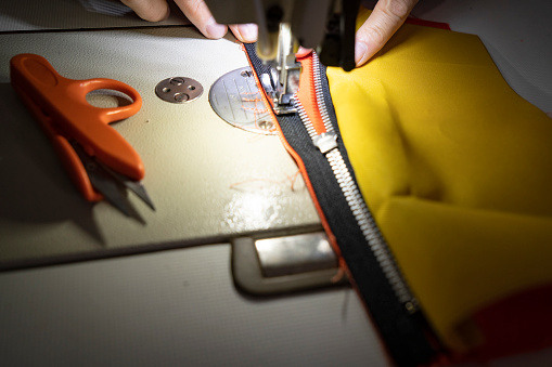 Man tailor at work on sewing machine.