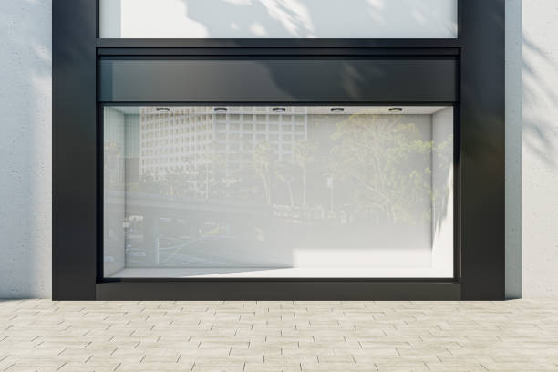 istock Front view on blank light wall background in empty shop window with place for your product presentation behind sunlit glass walls with city reflection in modern building outdoors. 3D rendering, mockup 1470448867