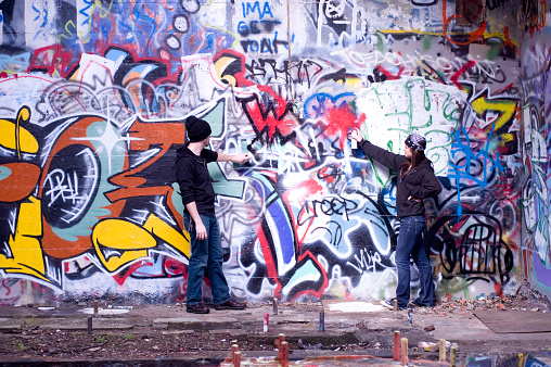 Young woman standing in front of the graffiti on the wall