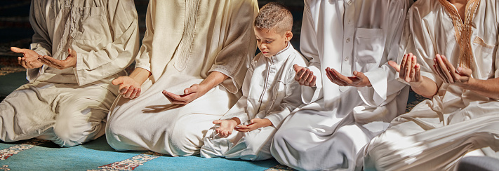 Muslim, child or men prayer to worship Allah in holy temple or mosque with gratitude as a family on Ramadan. Islamic, community or people in praying with boy or kid for Gods support, spiritual peace
