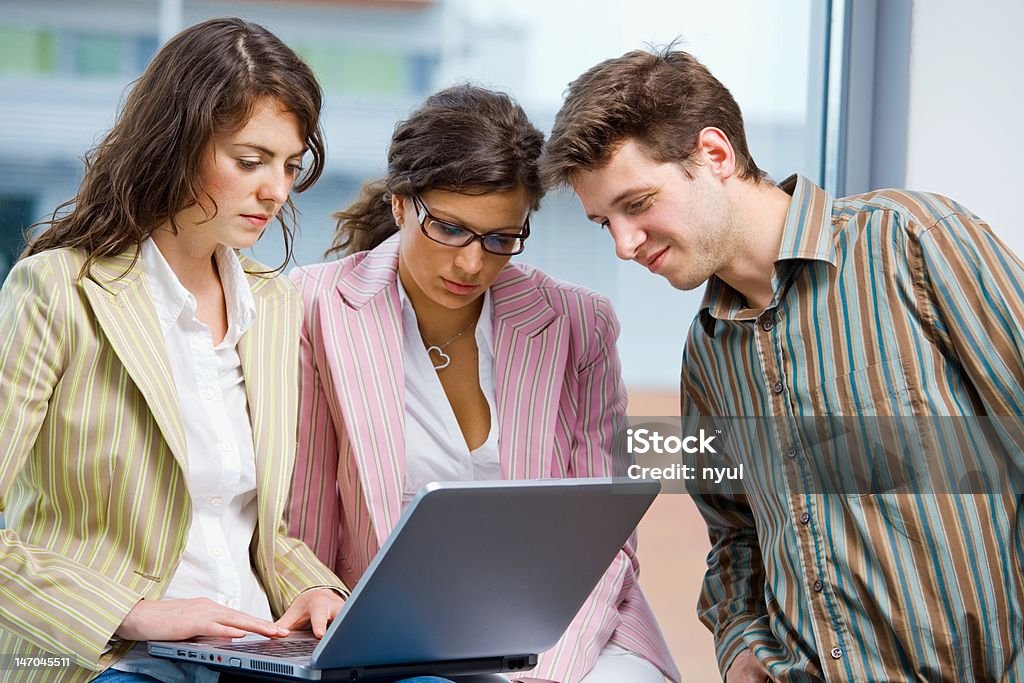 Businessteam working on computer Young businesspeople having meeting at office, working in team together on laptop computer. Click here for other business images: Achievement Stock Photo