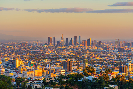 Gorgeous beauty of the Los Angeles skyline at sunset. The city's towering buildings are bathed in a warm glow, creating a magical atmosphere.