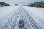 Car travelling ice road of a frzen lake