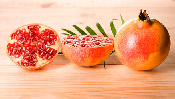 Pomegranate isolated on wood table stock photo