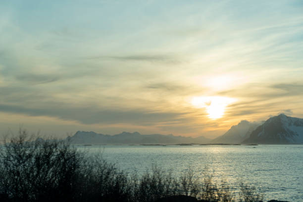 Winter sun over snow capped mountain range in Lofoten islands Norway