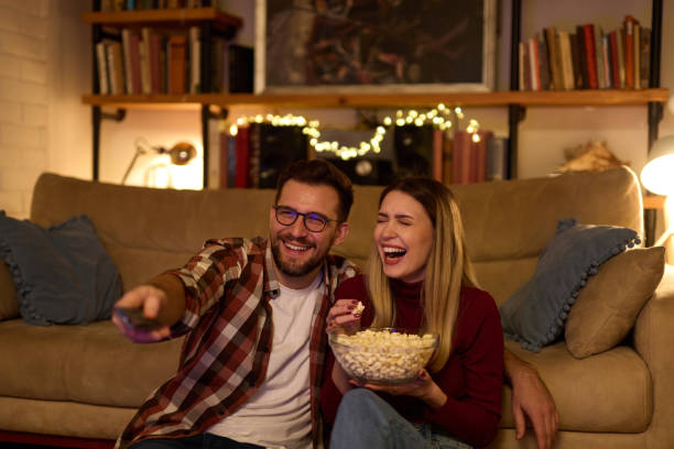 istock Young romantic couple watching TV at home 1470461124