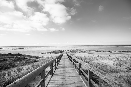 Wooden bridge in the dunes to the North Sea in Norddeich at winter,  East Frisia, Lower Saxony, Germany 2023