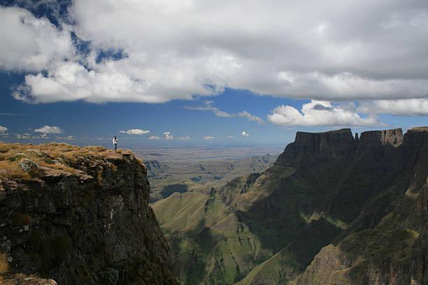The Drakensberg A person on the edge of the ampitheatre - Drakensberg - South Africa drakensberg mountain range stock pictures, royalty-free photos & images
