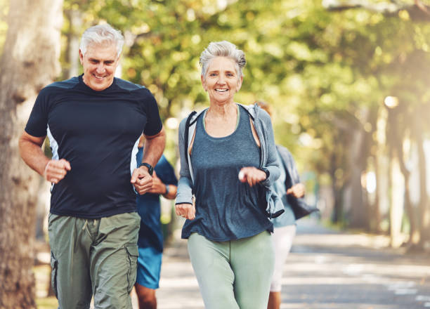 Senior runner group, park and fitness for smile, teamwork or motivation for wellness in summer sunshine. Happy elderly couple, friends or running team by trees for exercise, health or outdoor workout grupo de corredores senior, parque y fitness para la sonrisa, el trabajo en equipo o la motivación para el bienestar bajo el sol del verano. feliz pareja de ancianos, amigos o equipo de corredores junto a los árboles para hacer ejercicio, salud o entrena