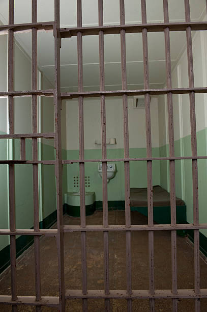 istock Stark prison jail cell with bed and toilet 147046823