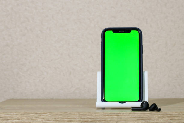 istock smartphone with a blank screen and wireless headphones at home on the table. 1470469544