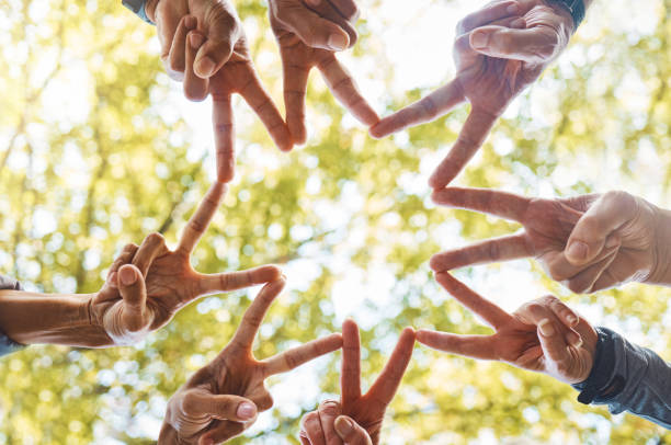 istock Hands, peace sign or team in nature with hope, support or team work for group vision, mission or goals success. Community, team building or people in partnership with motivation or teamwork in a park 1470473937