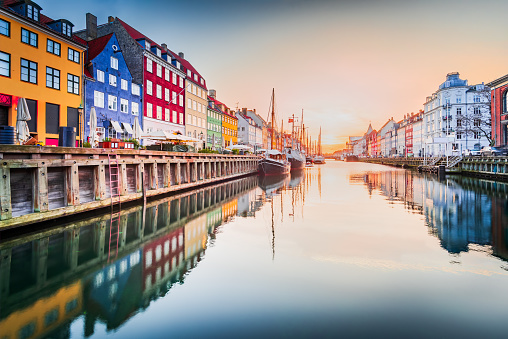 Charm of Copenhagen, Denmark at Nyhavn. Iconic canal, colorful sunrise, and breathtaking water reflections.