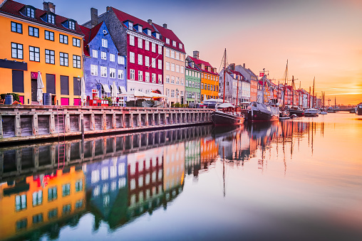 Copenhagen, Denmark. Charm of Nyhavn Canal, iconic place, colorful sunrise, and breathtaking water reflections.