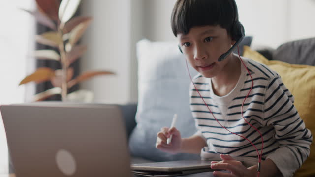Asian kid e-learning with online tutor at home