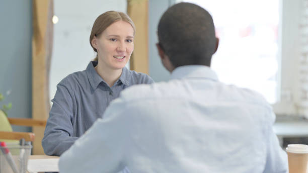 istock Young Woman Talking to African Man in Office 1470481452