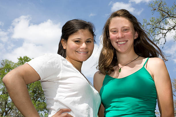 друзья на фоне неба. - hiking young women outdoors t shirt стоковые фото и изображения