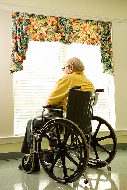istock Elderly Man in Wheelchair by Window 147048651