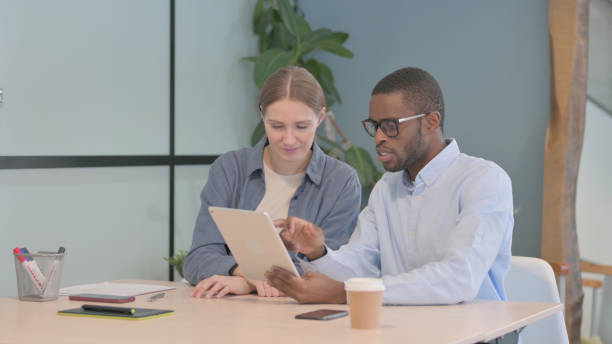 istock Young Business People Discussing Work on Tablet  in Office 1470488299