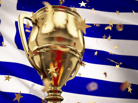 Greece Championship Concept Star Shaped Confetti Falling Onto A Gold Trophy Cup with Greek Flag. 3D Render