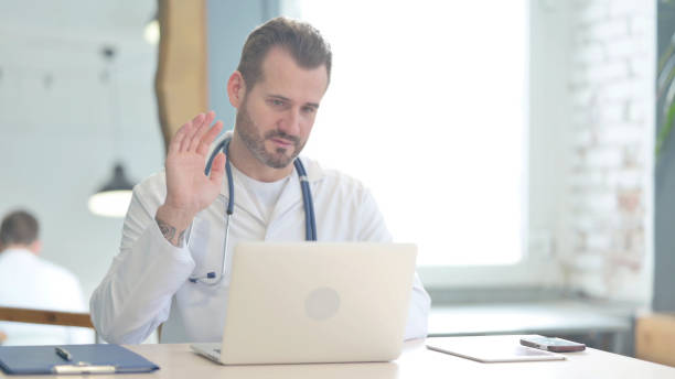 istock Doctor Talking on Video Call on Laptop in Clinic 1470489372