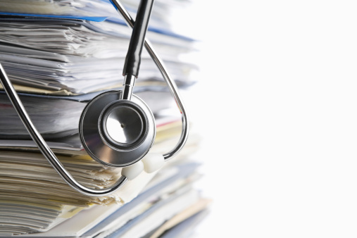 Medical record concept with stetoschope over pile of document. Selective focus on the front side of the stethoscope