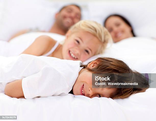 Family Resting In Parents Bed Stock Photo - Download Image Now - Boys, Child, Adult